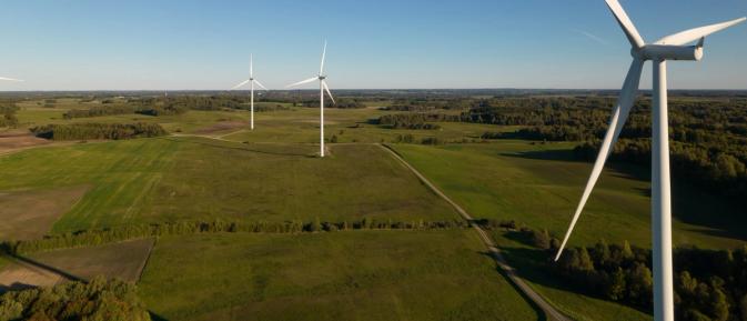 Wind turbines in a field which support the energy transition
