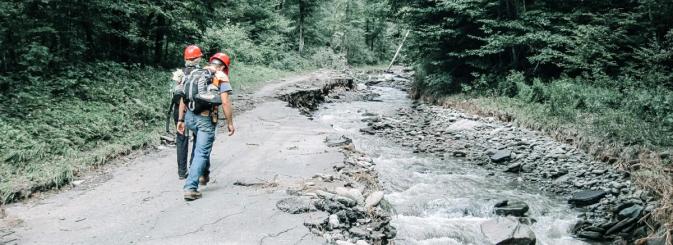 Workers with hard hats walking by a river