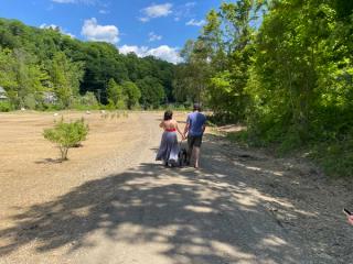 A woman and a man walking down the path in Kikitta Ahki floodplain restoration proj