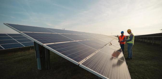 Two workers examining solar panels on site
