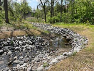 Watercourse filled with rocks in a residential area 